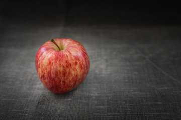 Fresh red apple on sackcloth. Selective focus.
