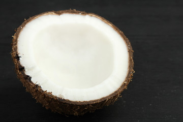 Fototapeta na wymiar coconut cut into pieces on a black wooden background
