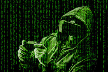 Double exposure of a caucasian man wearing a hoodie and Virtual reality ( VR ) headset is presumably as gamer or a hacker cracking the code into a secure network or server, with lines of code in green
