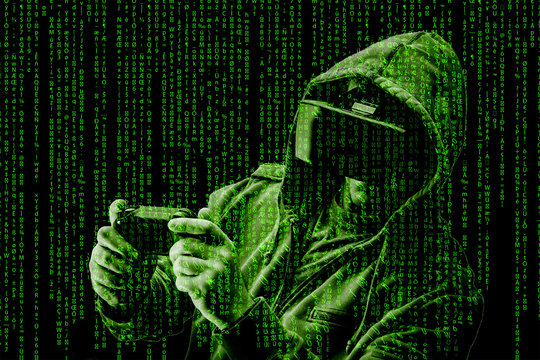 Double exposure of a caucasian man wearing a hoodie and Virtual reality ( VR ) headset is presumably as gamer or a hacker cracking the code into a secure network or server, with lines of code in green