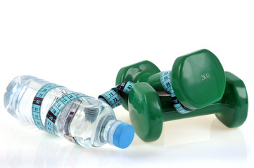 Bouteille d'eau avec des haltères et un centimètre souple