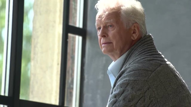 elderly caucasian man look at window, lost in thought