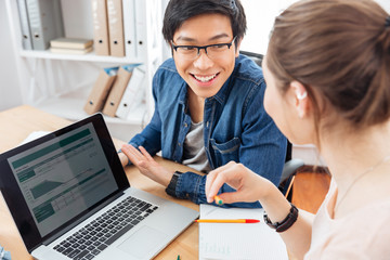 Two businesspeople using laptop and working together