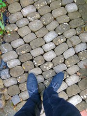 Blaue Schuhe auf Pflaster Stein