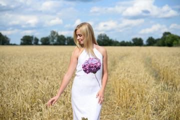Fototapeta na wymiar Portrait of beautiful young woman in white dress, wheat field