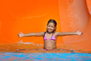Fototapeta premium Adorable toddler girl enjoying her summer vacation at aquapark