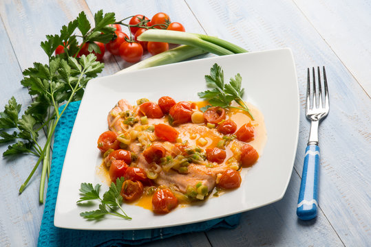 salmon trout fillet with leek and fresh tomatoes