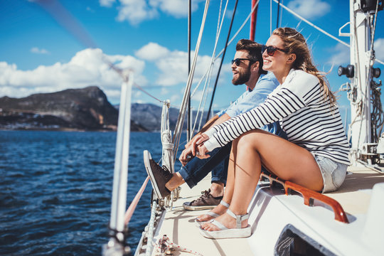  Young couple sitting on yacht in sea