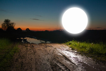 Glowing round sign on old rural road at sunset