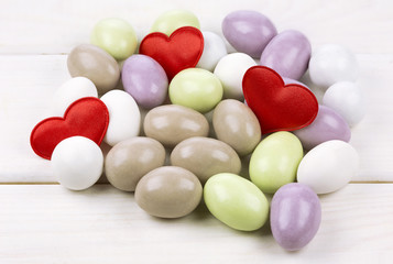 Sugared almonds with red heart shaped confetti