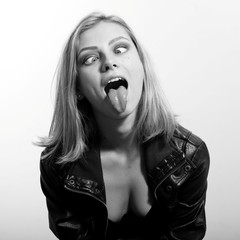 Black white photography of beautiful blonde young woman having fun making faces looking at nose, closeup photo 