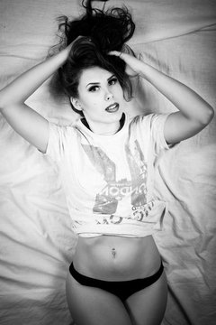 Black white photography of beautiful young lady in lingerie panties relaxing in bed