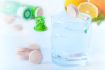     Multivitamin tablet in water with lemon and orange 