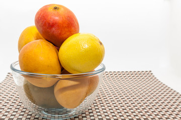 Ripe yellow and red mango fruits in glass bowl