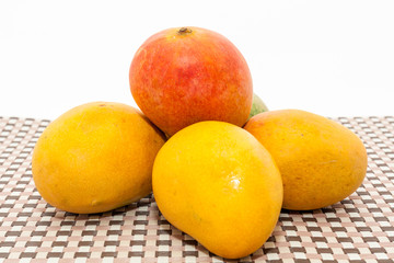 Ripe yellow and red colored mango fruits on mat background