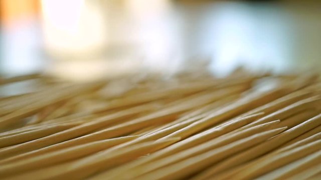 Man pouring toothpicks on the table and taking one macro slow motion video