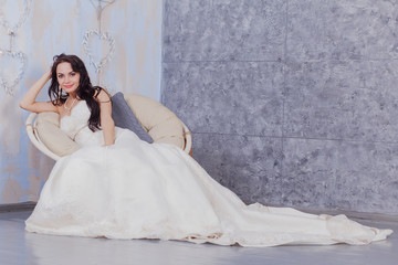 Beautiful innocent brunette bride in white dress posing