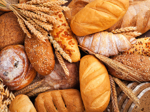 assorted breads on old wooden board.