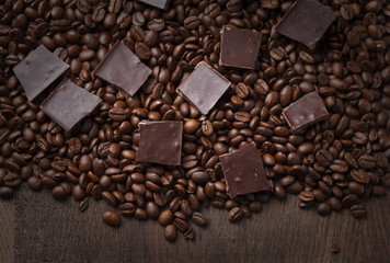 Coffee beans with chocolate on wooden background