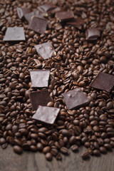 Coffee beans with chocolate on wooden background