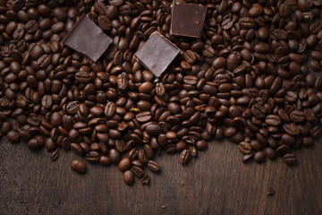 Coffee beans with chocolate on wooden background