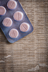 vertical view blister with medical pills on wood