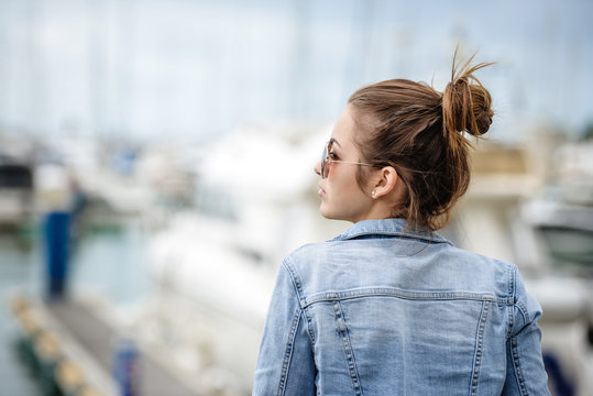 Young lady tourist enjoying view in marina watching yachts