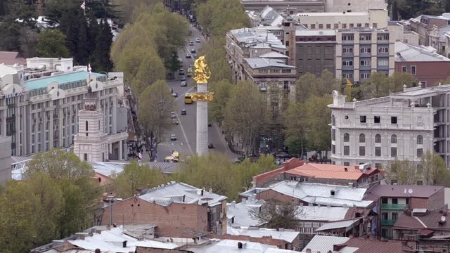 View of Tbilisi and the monument St. George, patron saint of Georgia. Movement of cars on the road