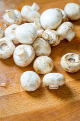 Whole Fresh White Mushrooms on Wooden Board.