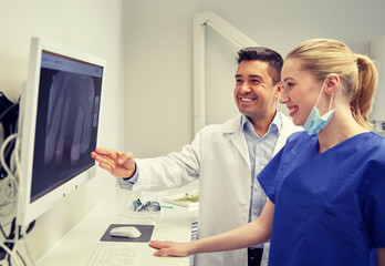 Obraz premium dentists with x-ray on monitor at dental clinic