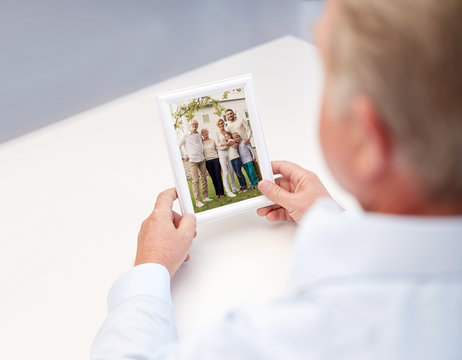 close up of old man holding happy family photo