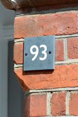 House Number 93 sign on wall