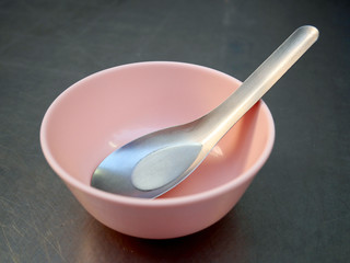 Set of a short spoon and a small pink plastic bowl