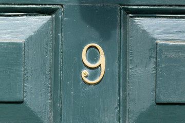House Number 9 sign on wooden door
