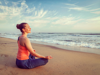 Fototapeta na wymiar Young sporty fit woman doing yoga oudoors at beach