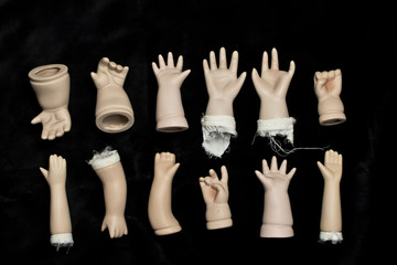 Broken Doll Body Parts on Black Background