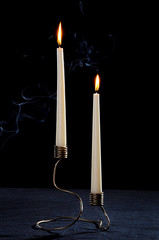 Unusual candlestick handmade metal work for the high-candles on a black background