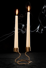 Unusual candlestick handmade metal work for the high-candles on a black background