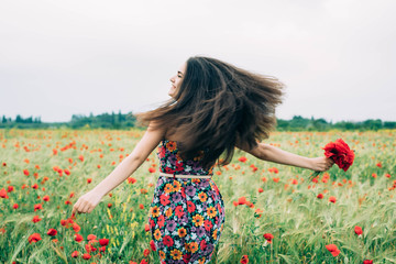 young beautiful woman having fun in poppy field 