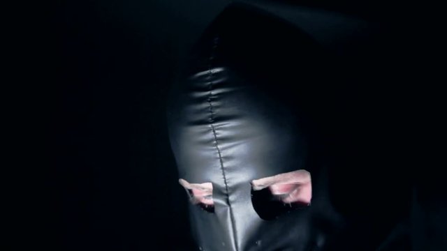 A man in a leather mask dances