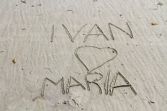 Kärlekshälsning skriven på sandstrand