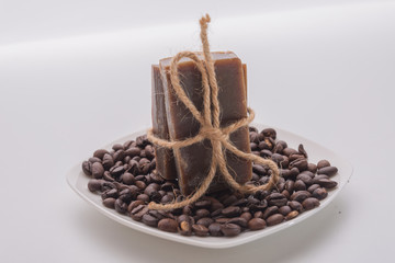 Traditional home made natural coffee soap with a pile of coffee beans on the background suggesting healthy organic non toxic wash products