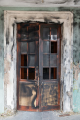 Scorched broken door of abandoned house