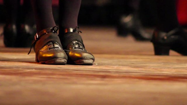 People doing Irish dance on stage with traditional shoes at a folk festival