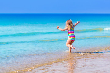 Fototapeta na wymiar Little girl playing on tropical beach