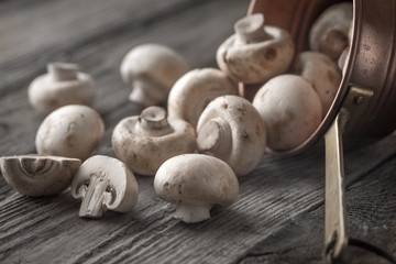 Champignon on the copper pot on the wooden table horizontal