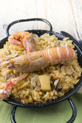 Vegetable paella with seafood on a wooden background