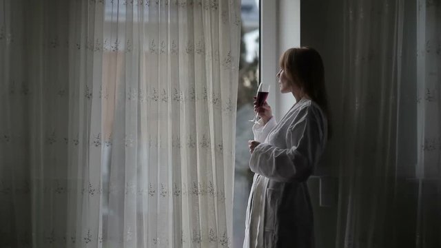 Pretty mid aged woman looking out the window.
