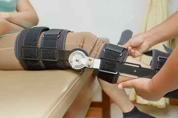 Orthopedist secures leg brace on knee, knee brace support for le