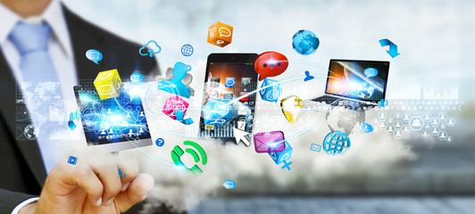 Businessman holding tech devices and icons applications over a c © sdecoret